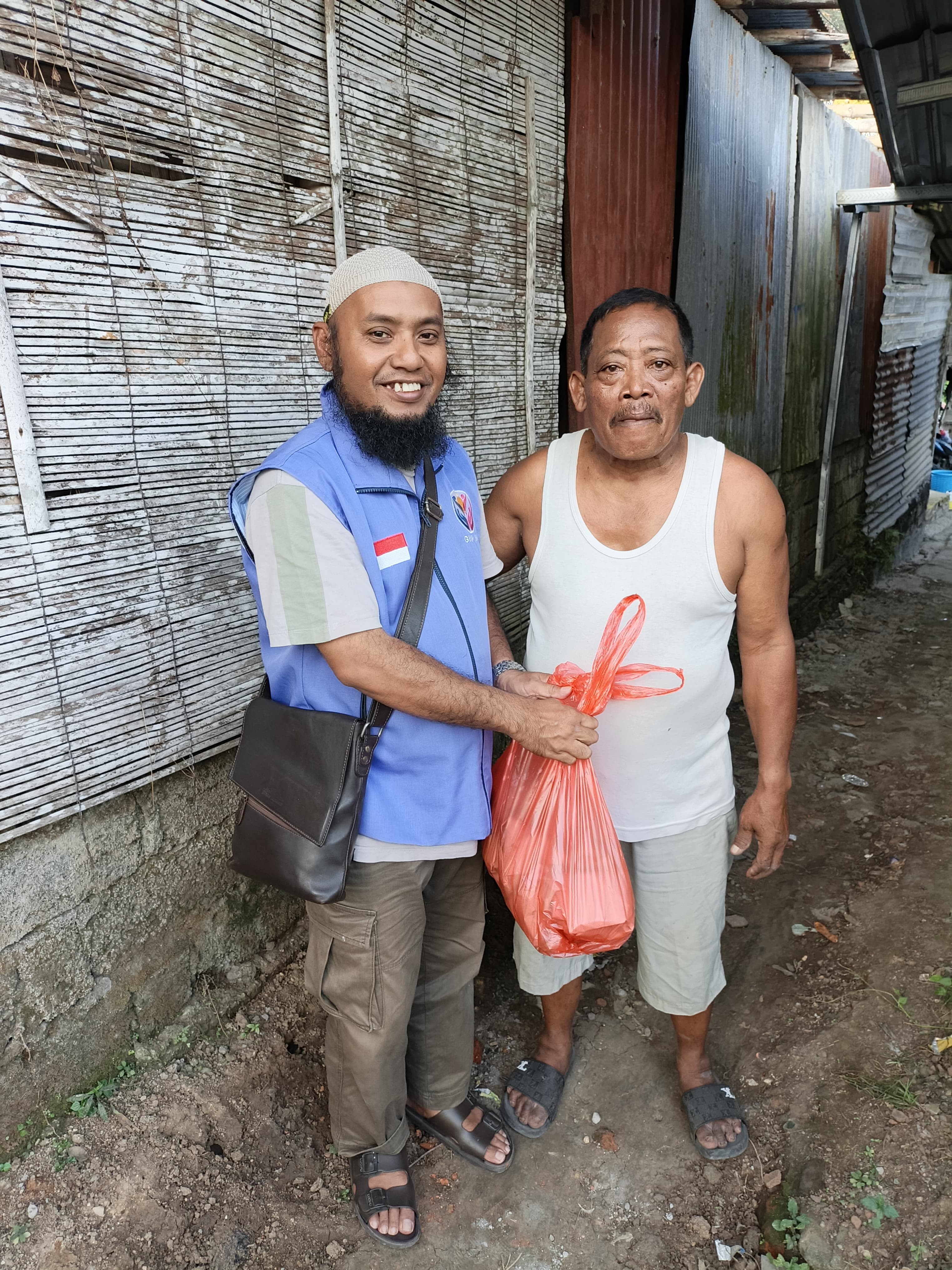 Suasana penyaluran paket nasi fidyah kepada warga